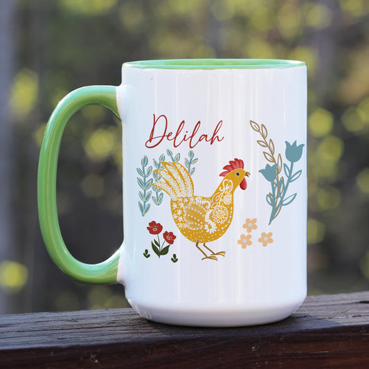 Chicken and rooster themed green handle ceramic mug with floral designs in blue, yellow, and red. Personalized with name Delilah in script.