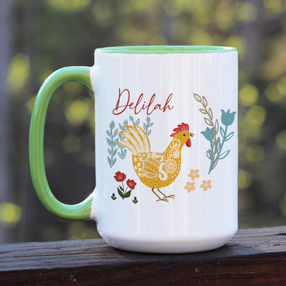 Chicken and rooster themed green handle ceramic mug with floral designs in blue, yellow, and red. Personalized with name Delilah in script.