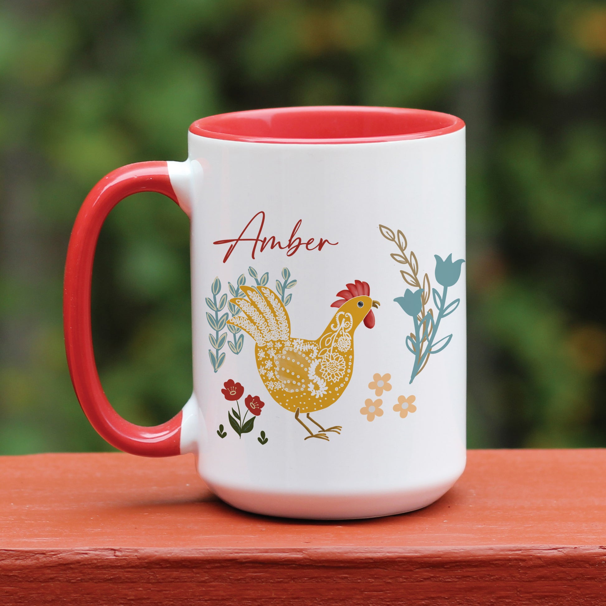 Chicken and rooster themed red handle ceramic mug with floral designs in blue, yellow, and red. Personalized with name Amber in script.