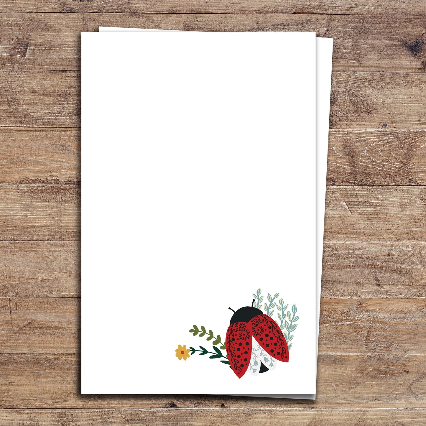 Two Floral Ladybug notepads on wood background