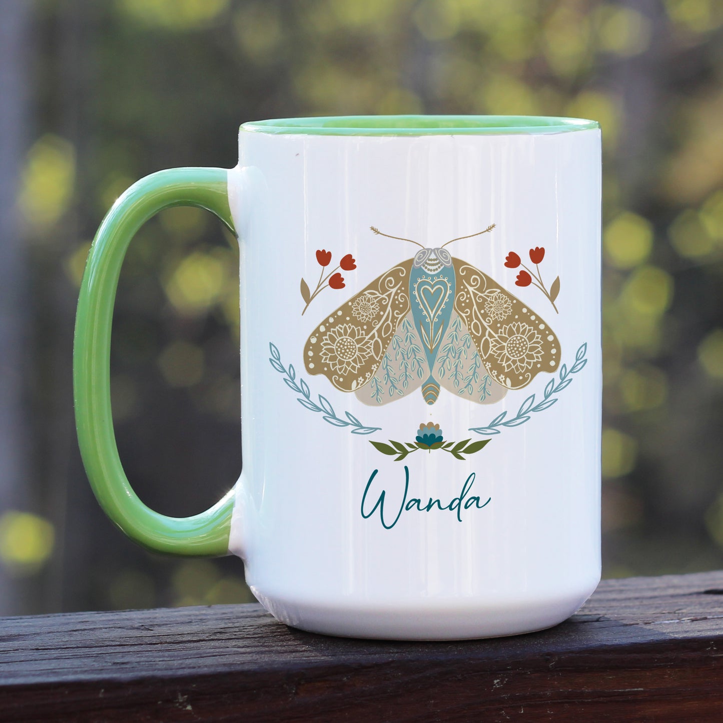 Boho floral moth mug personalized with name. The mug has a green handle.
