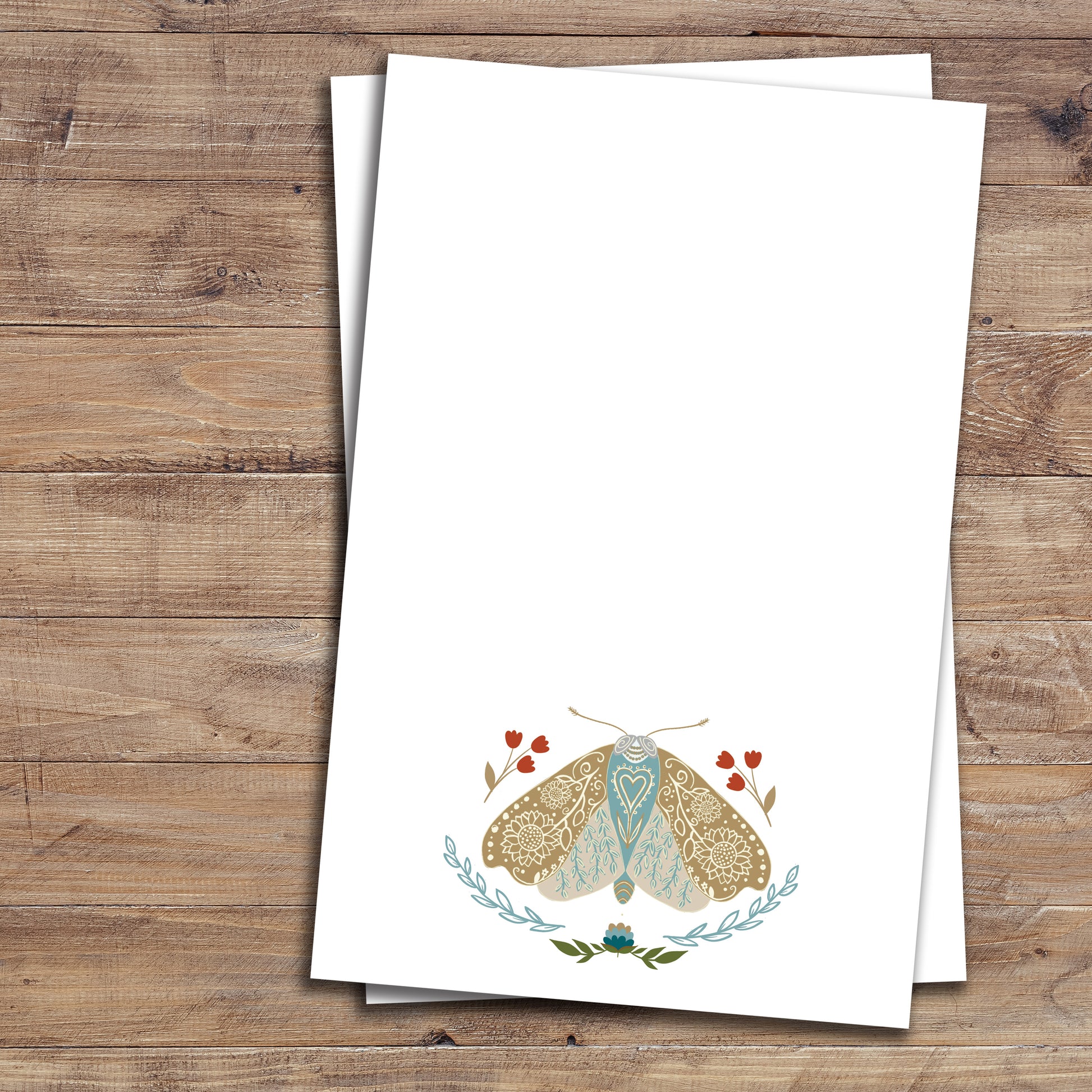 Two floral moth notepads on wood background