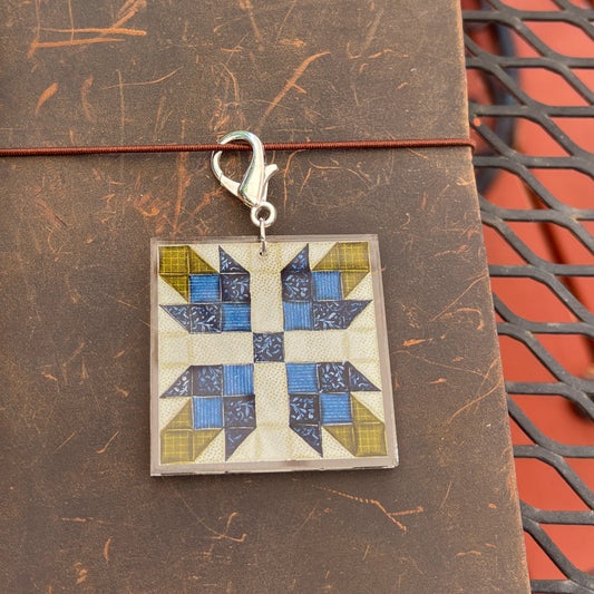 Journal charm with blue flower quilt block design against leather background