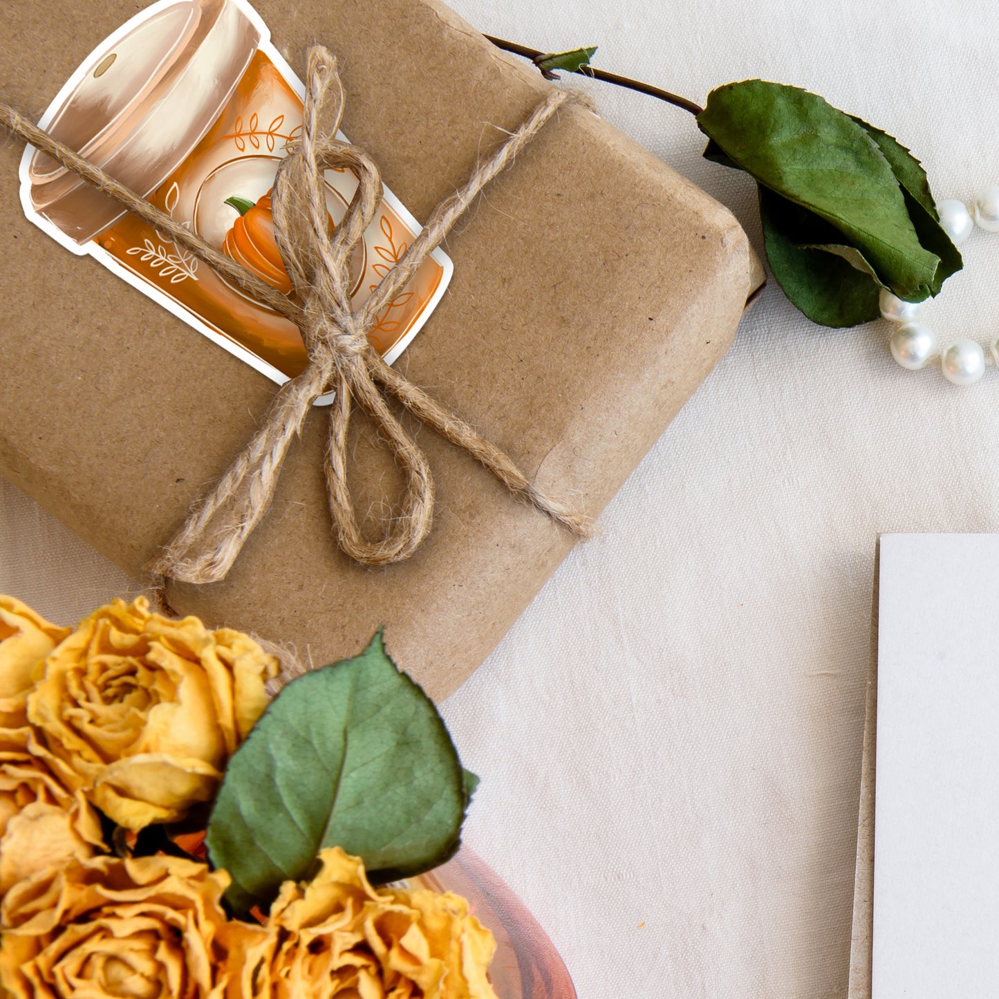 Pumpkin Spice Latte Fall Coffee Cup UV Vinyl Sticker on brown paper wrapped gift with yellow flowers.