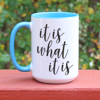 It is what it is white coffee mug with blue handle.