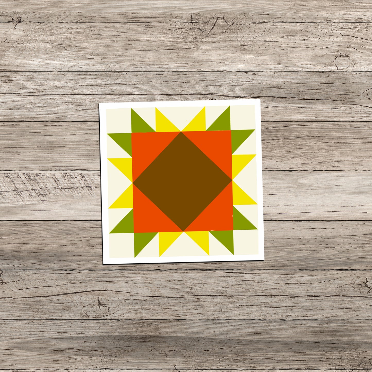 Sunflower Barn Quilt square sticker in orange, yellow, and green on a weathered light gray wood background.