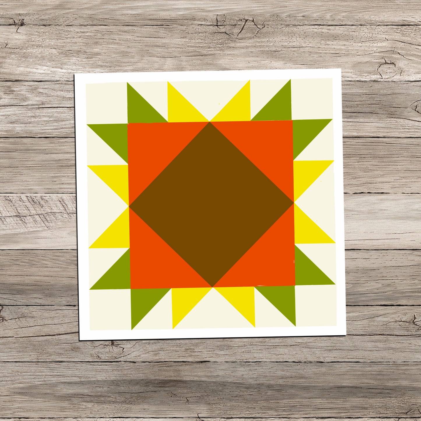 Sunflower Barn Quilt square sticker in orange, yellow, and green on a weathered light gray wood background.