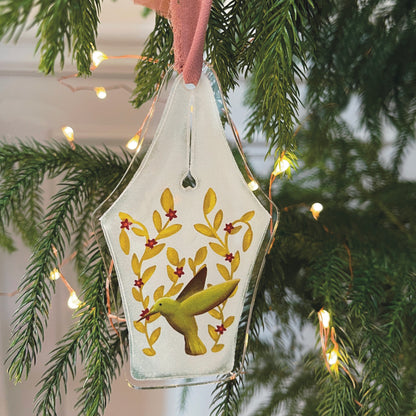 Acrylic fountain pen nib ornament featuring flowers and green hummingbird on Christmas tree with lights