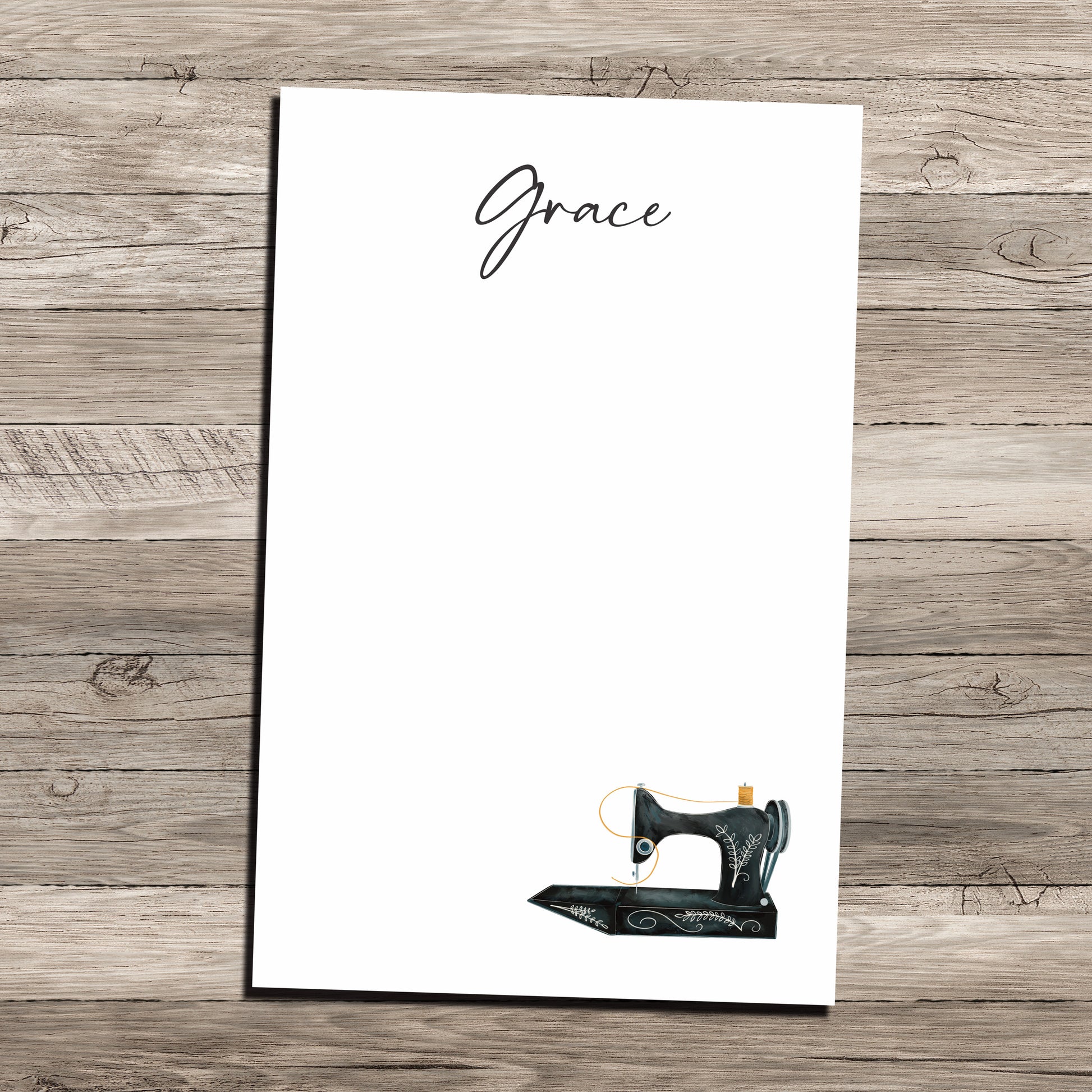 Antique sewing machine personalized notepad on wood background.