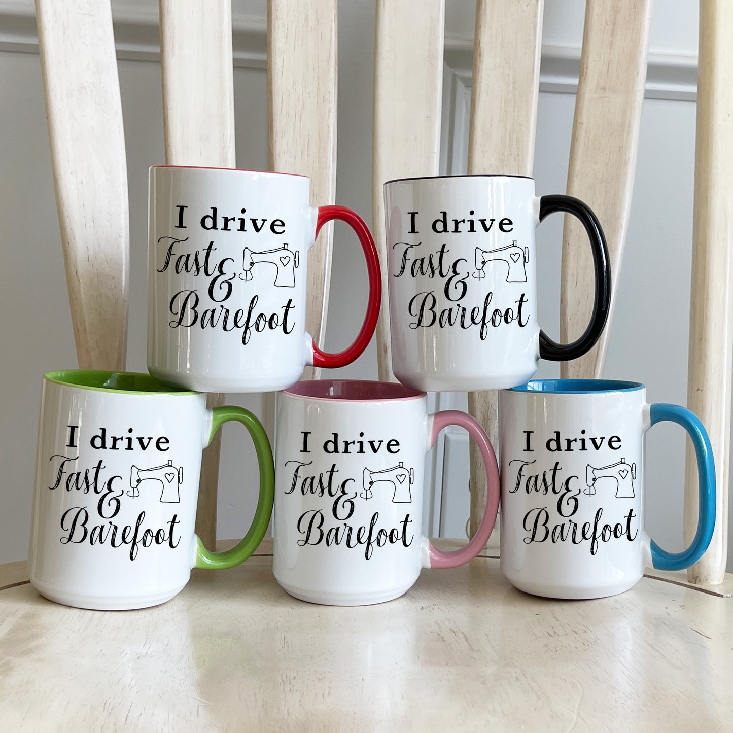 Five mugs with I Drive Fast and Barefoot design on each of the color accent mugs. The accent colors are red, black, green, pink, and blue.