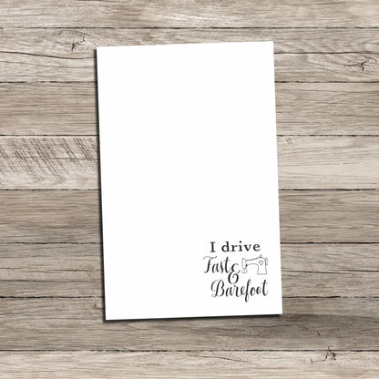 Personalized notepad featuring a sewing-themed phrase at the bottom that reads 'I drive Fast & Barefoot' with a sewing machine illustration, printed on a white background with a wood-textured backdrop.