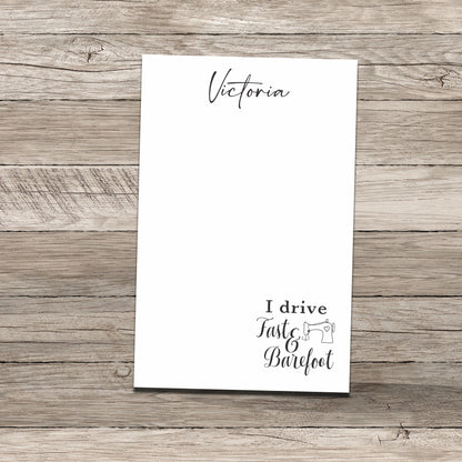 Personalized notepad set featuring the name 'Victoria' at the top and a sewing-themed phrase at the bottom that reads 'I drive Fast & Barefoot' with a sewing machine illustration, printed on a white background with a wood-textured backdrop.