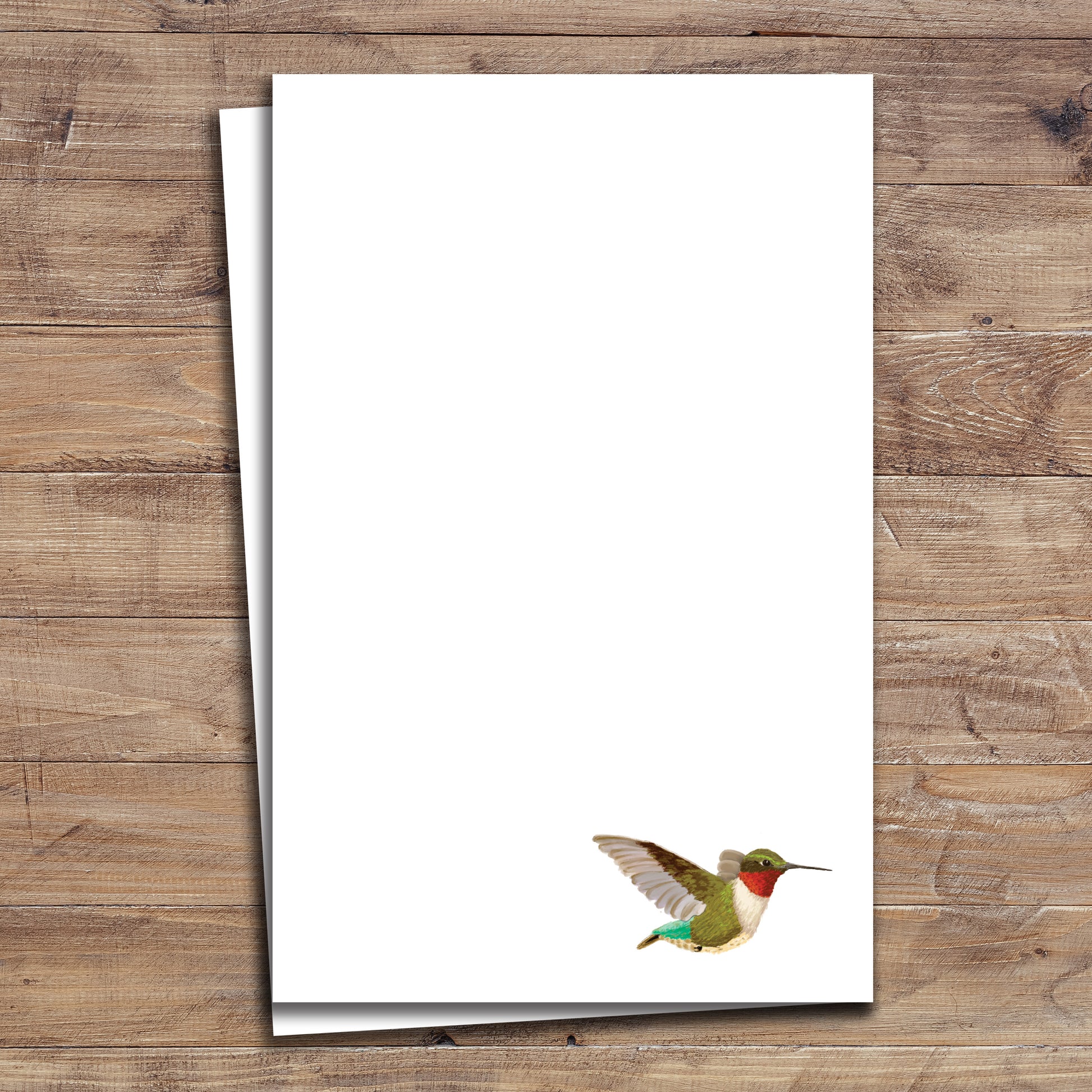 Two Hummingbird notepads on wood background