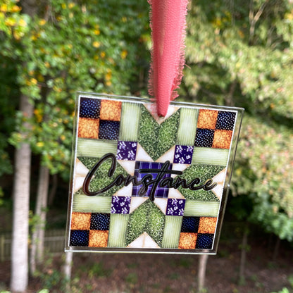 Personalized quilt block Christmas ornament with chiffon ribbon. Blue, purple, greens,and browns.