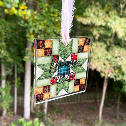 Personalized quilt block Christmas ornament with chiffon ribbon. Blue, red, greens,and browns.