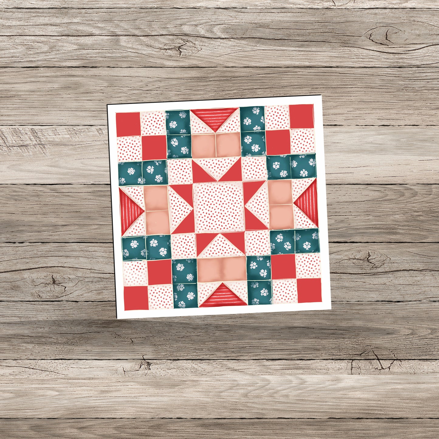 A colorful quilt pattern featuring a combination of teal, red, and peach squares and triangles arranged in a geometric design, displayed on a wooden background.