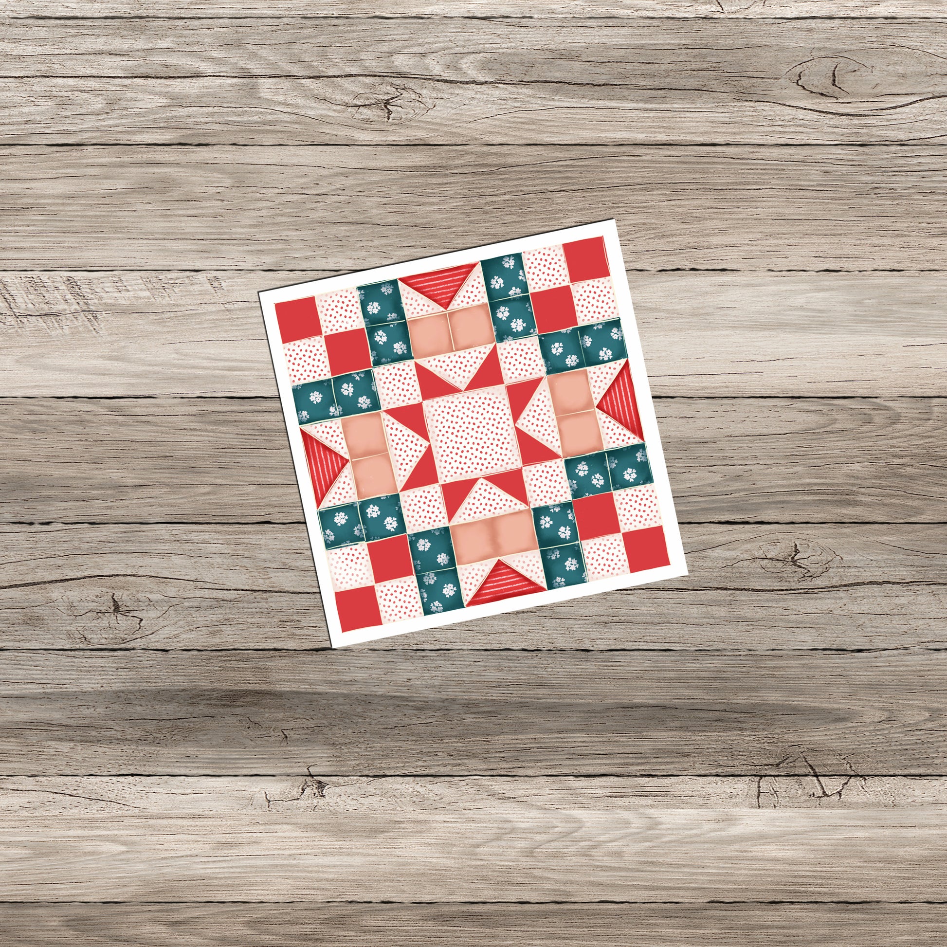 A colorful quilt pattern featuring a combination of teal, red, and peach squares and triangles arranged in a geometric design, displayed on a wooden background.