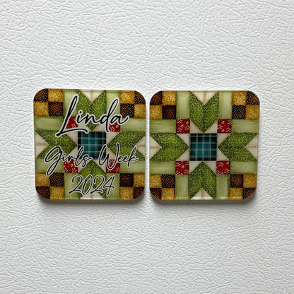 Two red and green quilt block design square acrylic magnets on white surface. One magnet is personalized with text that says "Linda Girls Week 2024."