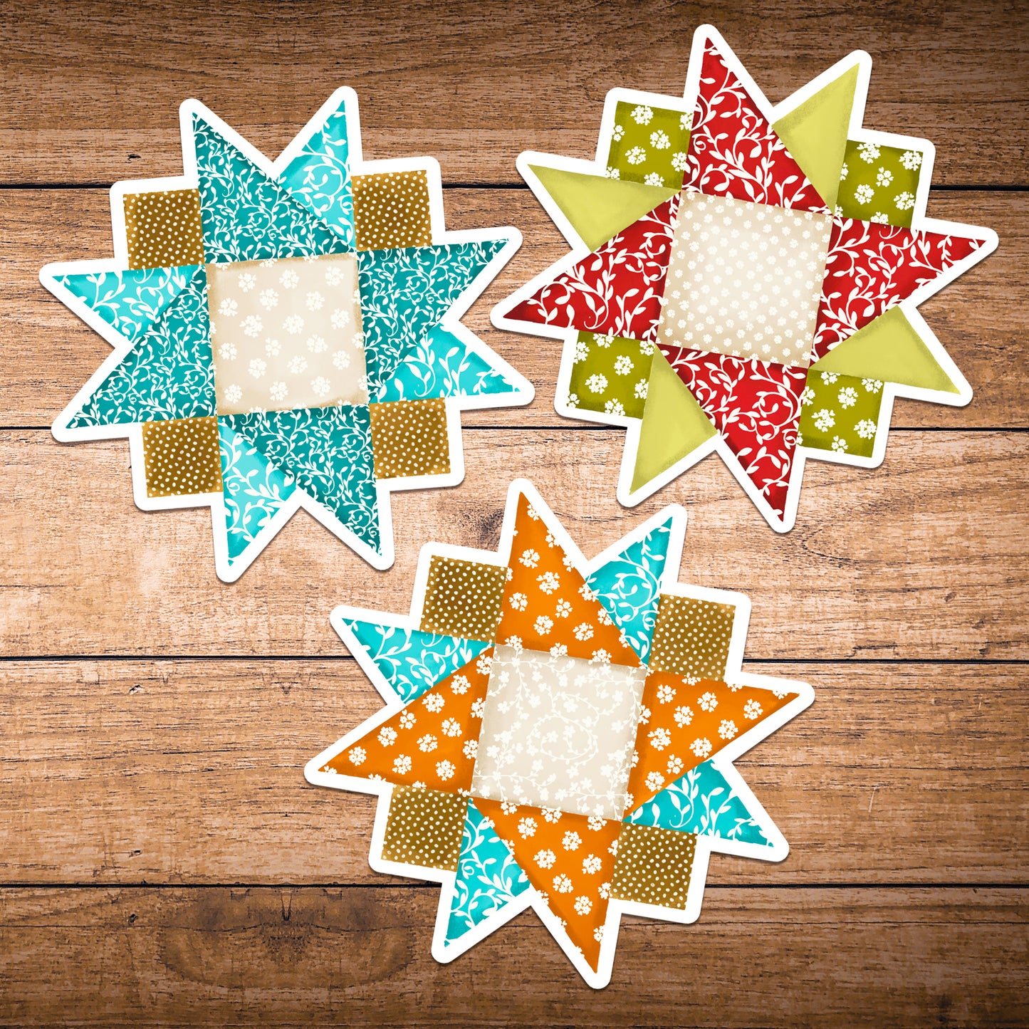 Set of three quilt block stickers blues, reds and orange on a dark wood background.