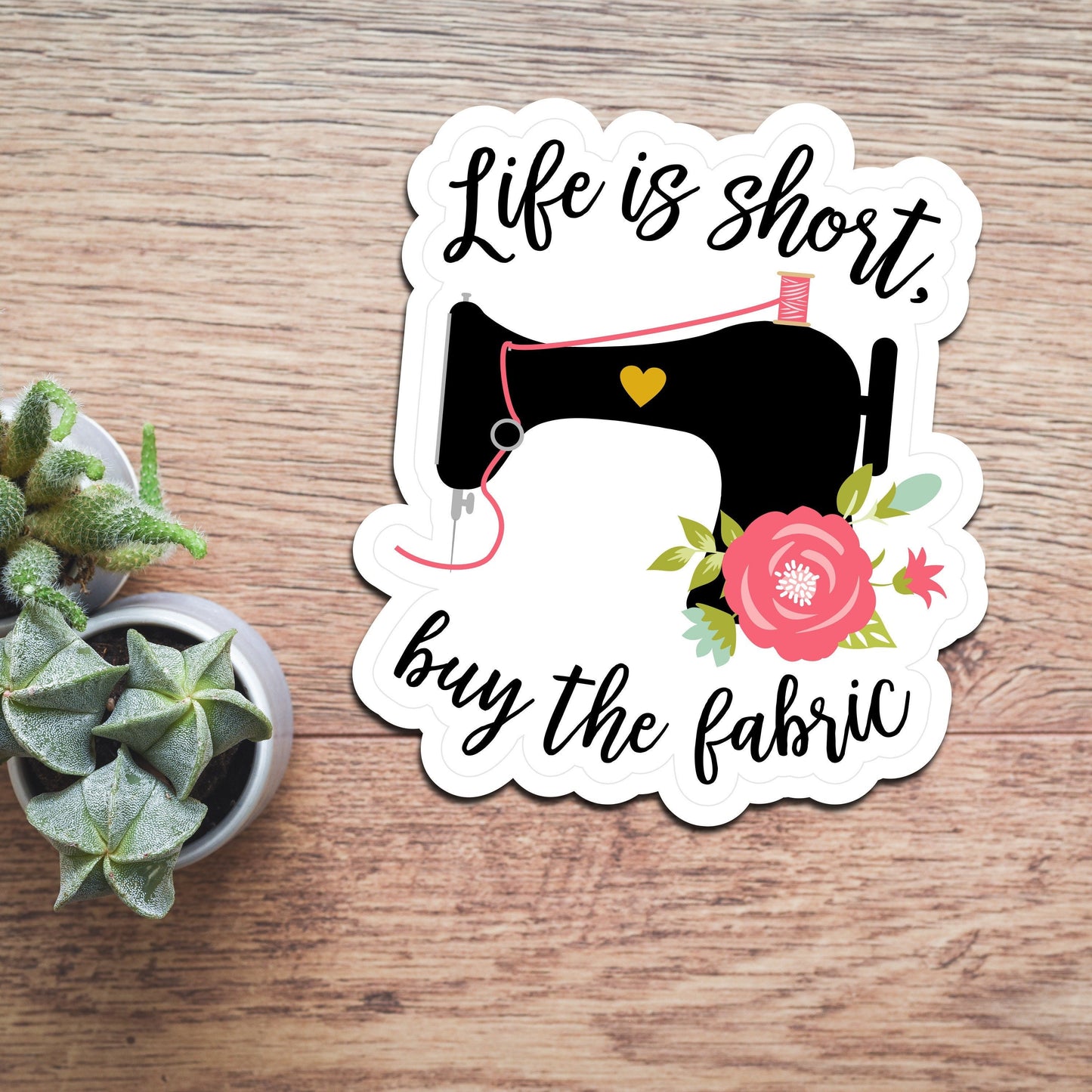 Life is short Buy the fabric Quilting Sewing sticker with pink accents on wood backdrop